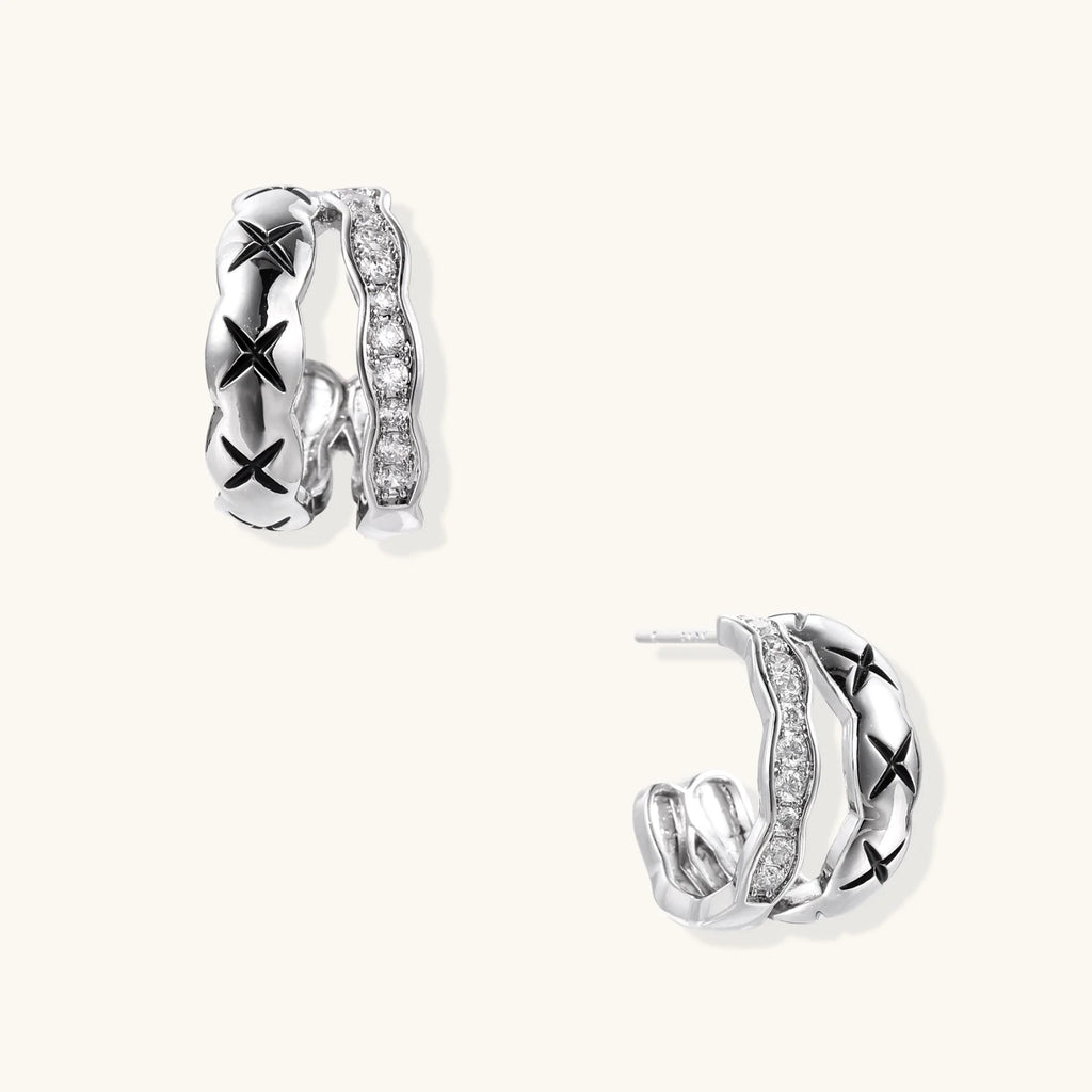 Triple-row white gold hoops with black X-pattern, twisted band, and pavé zirconia stones on white background.