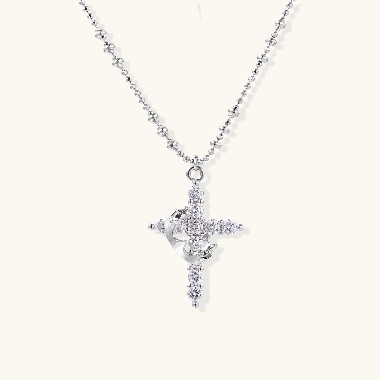 White gold-plated cross pendant adorned with sparkling zirconia stones and crescent moon accent on ball chain