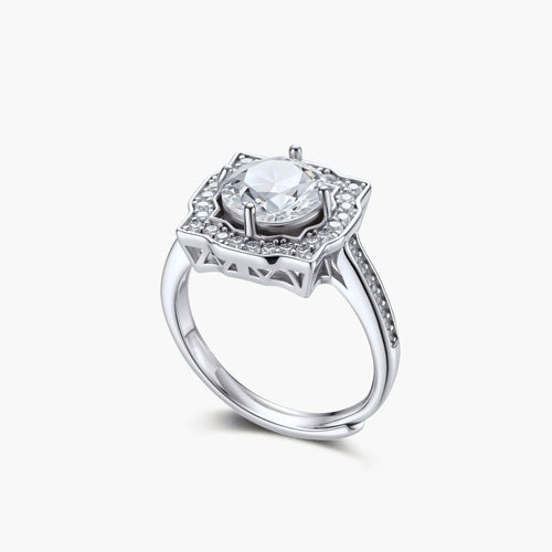 Sterling silver ring with round moissanite center stone in ornate scalloped halo setting on white background.
