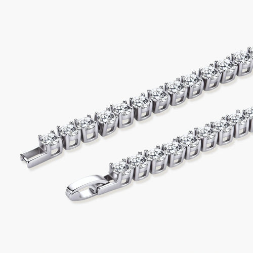 Sterling silver tennis bracelet with continuous row of brilliant moissanite stones and secure clasp closure on cream background.