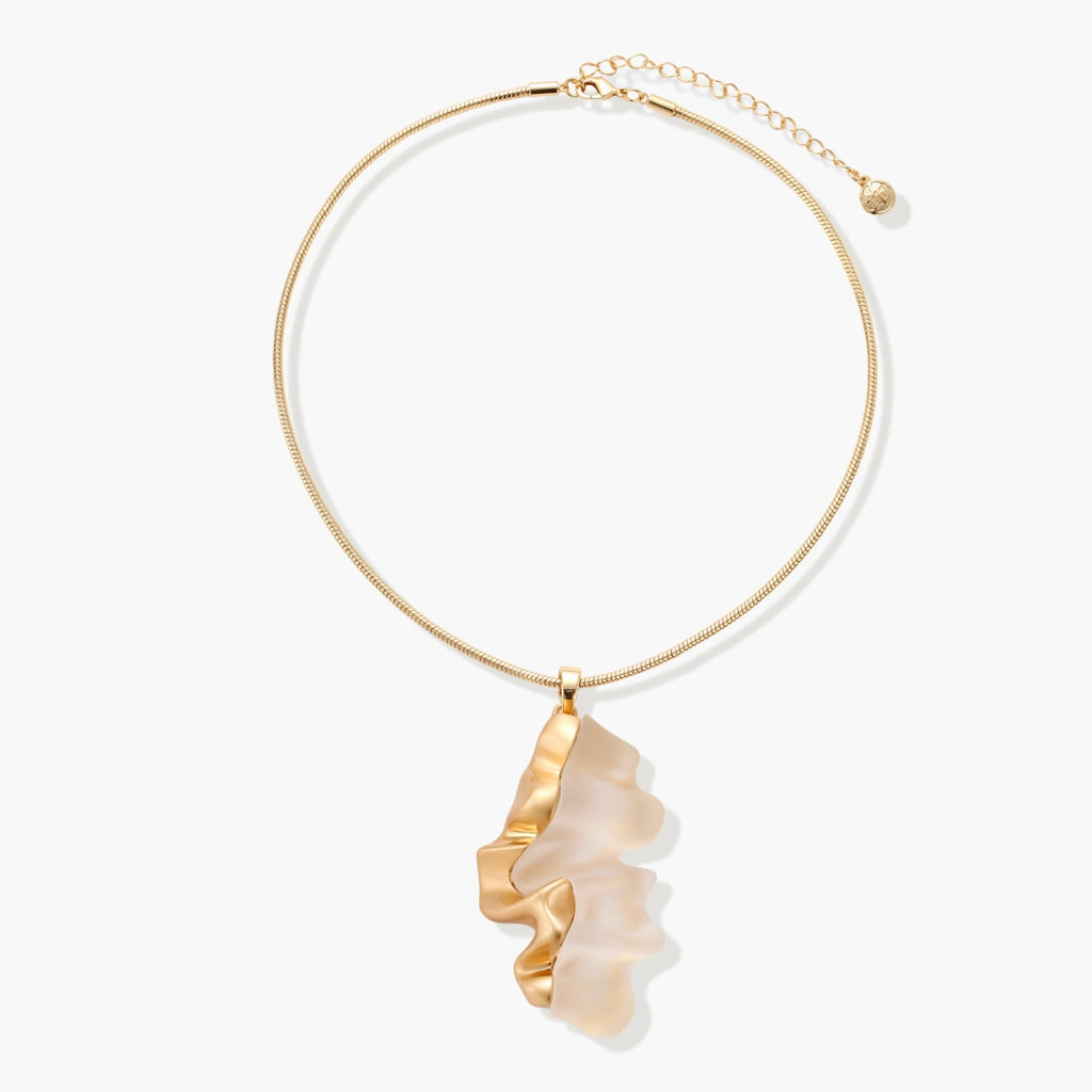 Close-up of a sculptural necklace with flowing wave pendant made from eco-zinc alloy on adjustable chain