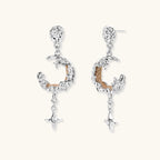 Detailed eco-brass dangle earrings featuring crescent moons with gold rope details and dangling star charms on white background.