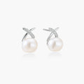 Rhodium-plated silver stud earrings with sparkling X design above lustrous round freshwater pearls on white background.