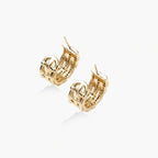 Gold-plated geometric hoop earrings with basket-weave lattice design and pavé crystal accents on cream background