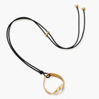 Geometric circle pendant necklace with crystal cluster on adjustable black cord, available in gold and silver finishes.