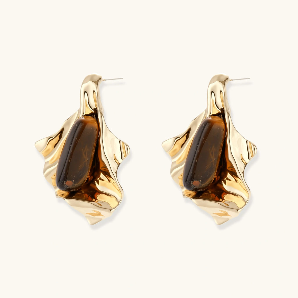 Sculptural stud earrings with organic twisted metal design holding brown gemstones, shown in gold and silver finishes.