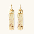Cylindrical bar earrings featuring speckled natural resin center with polished metal caps and lever-back closures