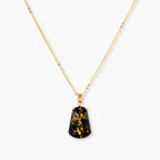 18k gold-plated necklace and earrings with green amber pendants featuring golden inclusions on cream background