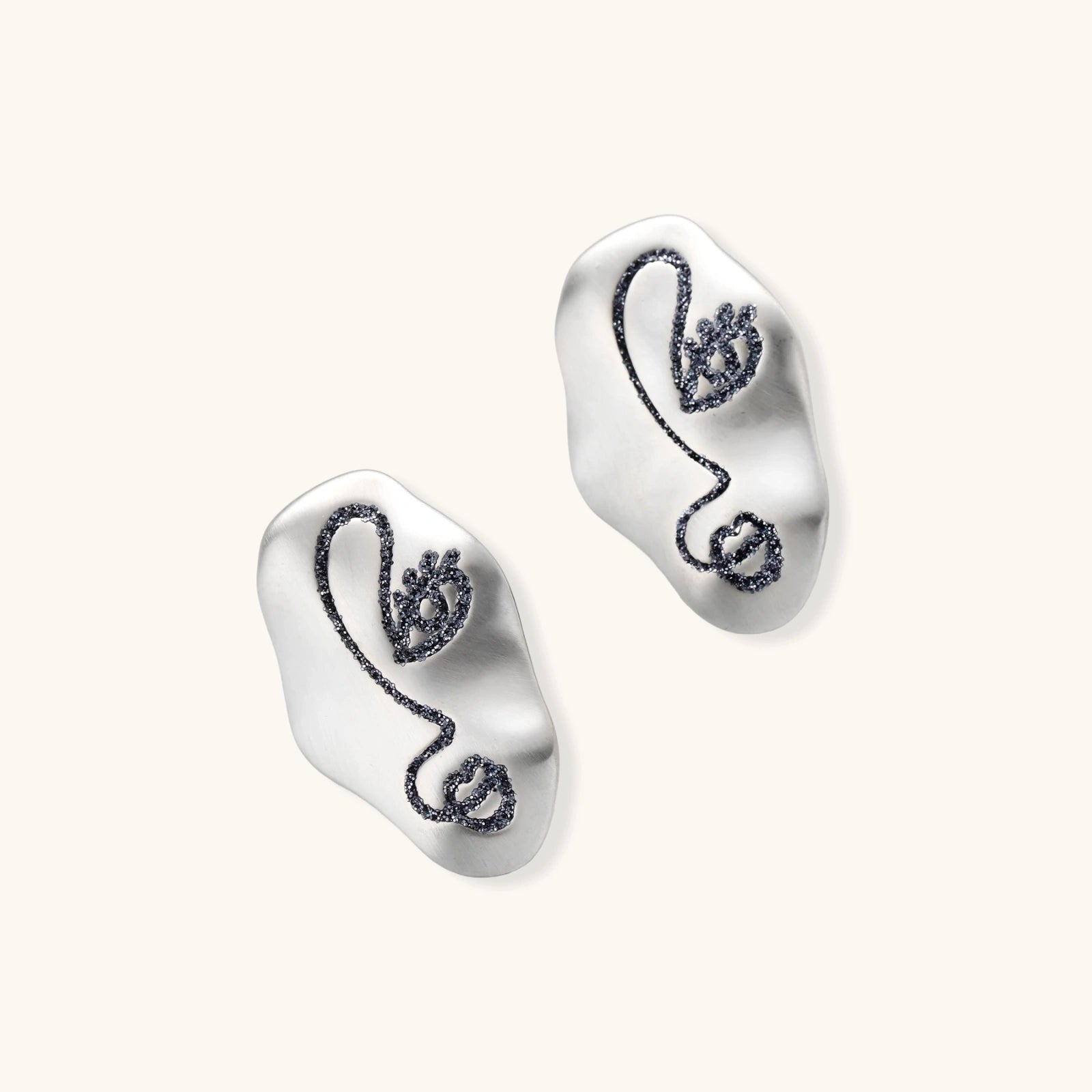 Artistic ear-shaped earrings with minimalist face line art on clear eco-zinc alloy base with sterling silver posts.