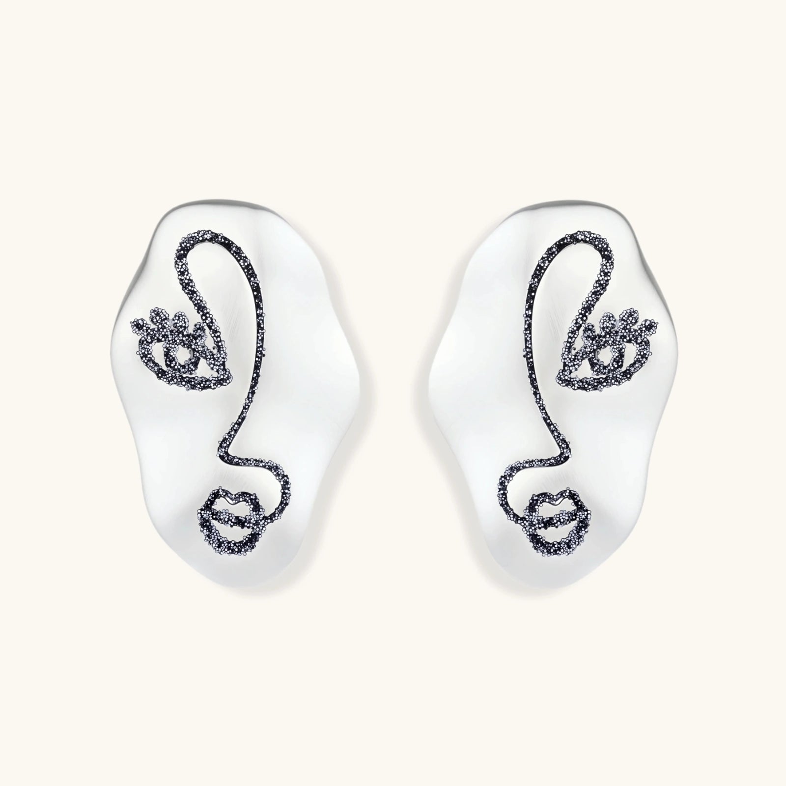Artistic ear-shaped earrings with minimalist face line art on clear eco-zinc alloy base with sterling silver posts.