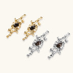 Flowing silver-toned earrings with organic liquid shapes and embedded brown resin stones on white background.