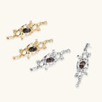 Flowing silver-toned earrings with organic liquid shapes and embedded brown resin stones on white background.