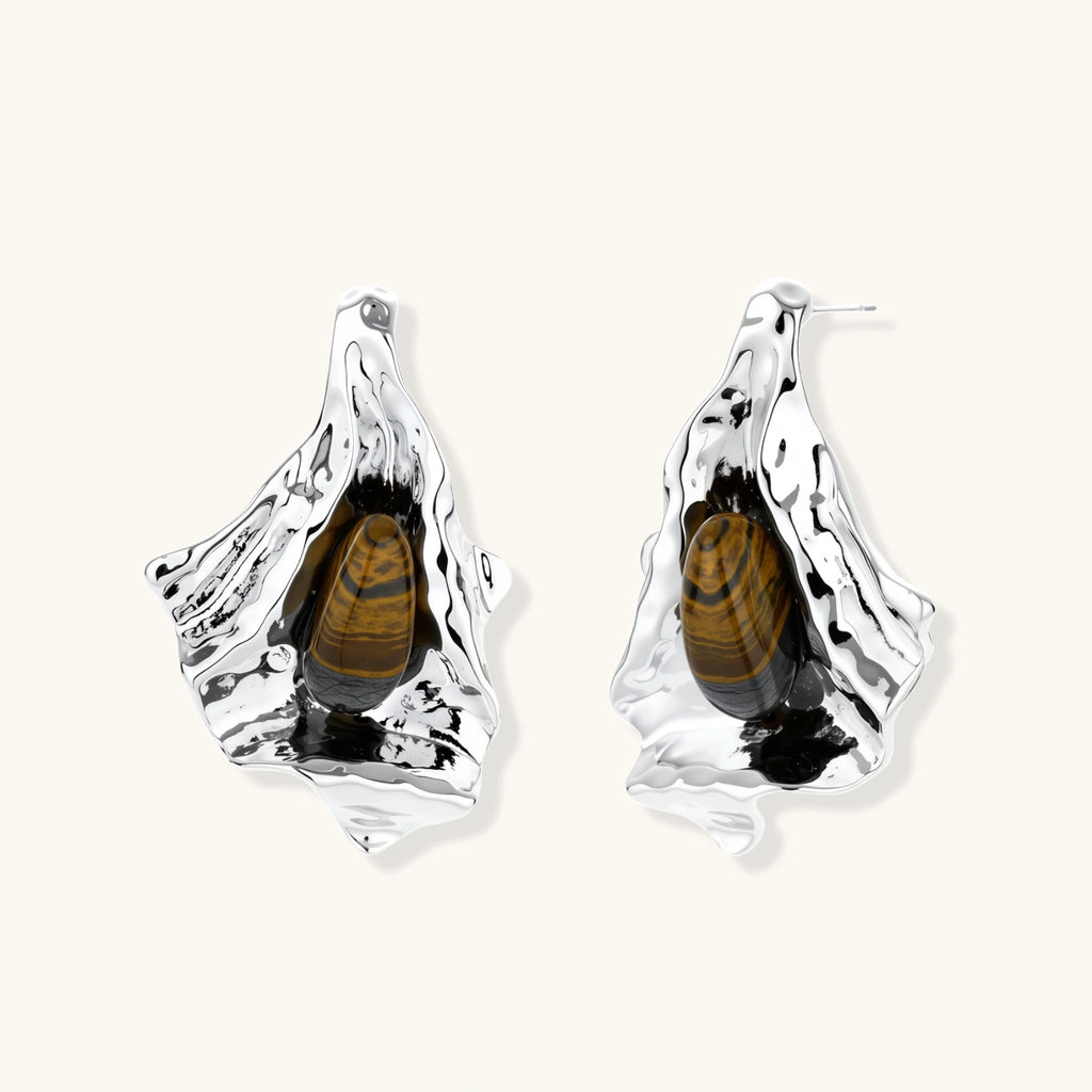 Silver sculptural earrings with flowing molten forms and amber gemstones, featuring 925 silver posts on white background.