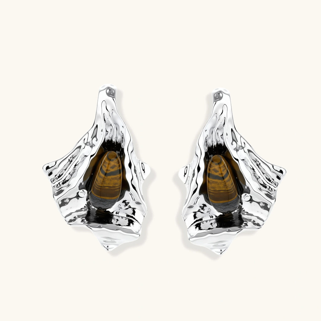 Silver sculptural earrings with flowing molten forms and amber gemstones, featuring 925 silver posts on white background.