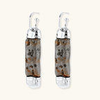 Cylindrical resin earrings with gray stone-like patterns and silver-toned metal caps, hanging against white background