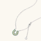 Geometric horseshoe-shaped jewelry set with radiating white zirconia center and jade-green border stones on white background.