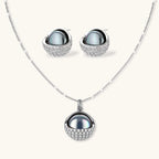 White gold plated spherical jewelry set with zirconia crystal pavé and dark lustrous centers on neutral background.