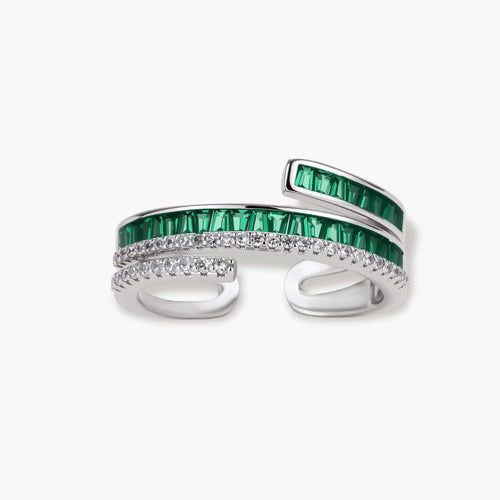Modern adjustable ring with green baguette stones and clear crystals in parallel bands on white background.