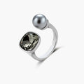 Modern adjustable ring with smoky zircon stone and metallic sphere in platinum-plated copper finish on neutral background.
